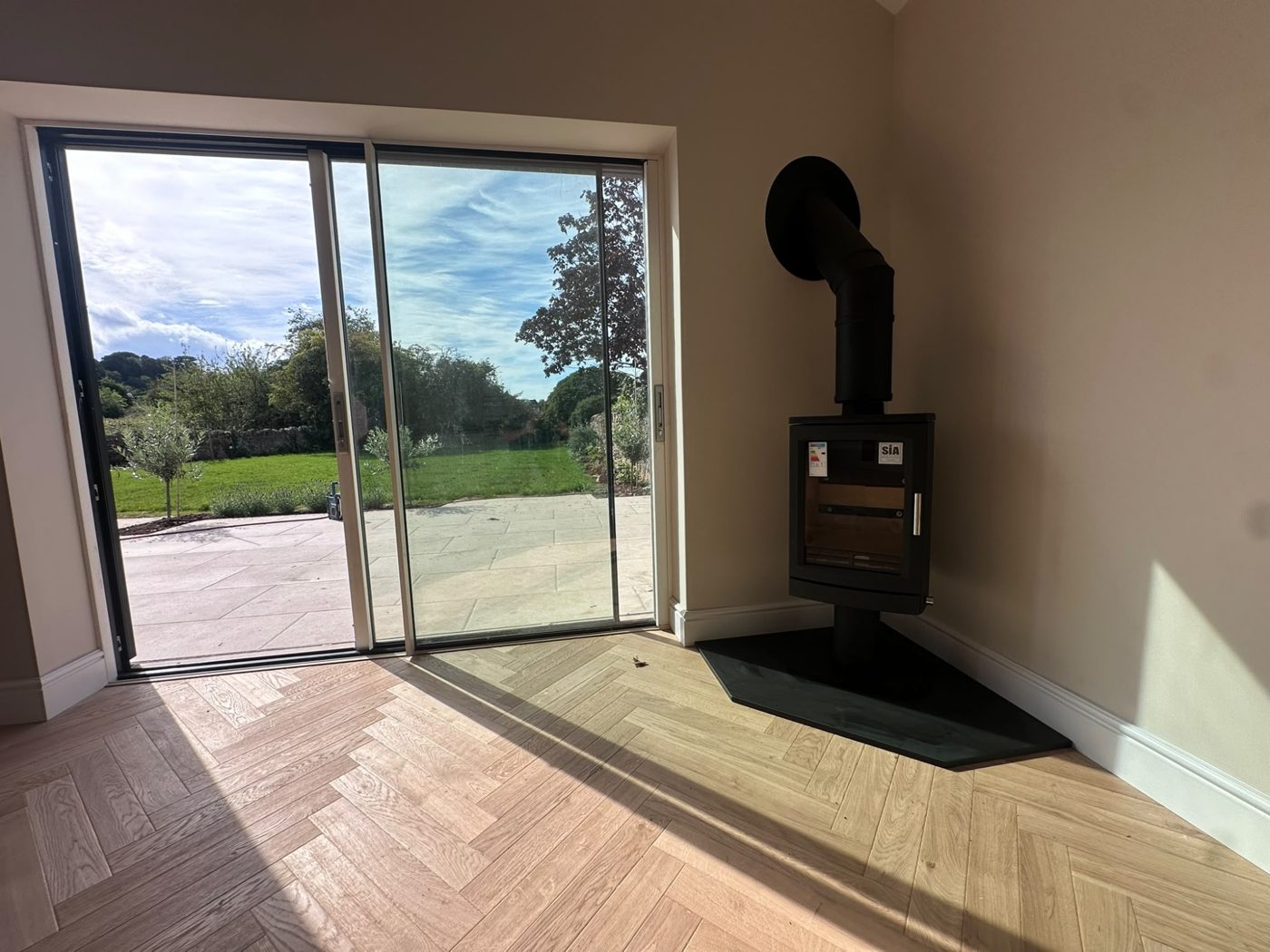 Wood burner beside sliding garden doors on a black hearth